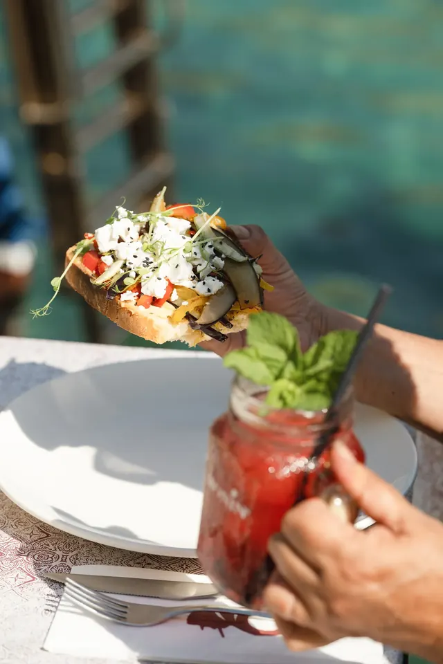 Guest enjoying vegetable bruschetta and a red drink